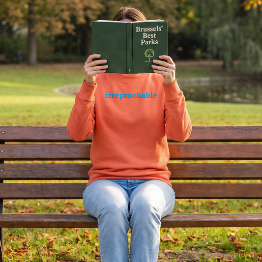 Woman in Fiesta Irrèprochable sweatshirt reading on a park bench in Brussels in autumn